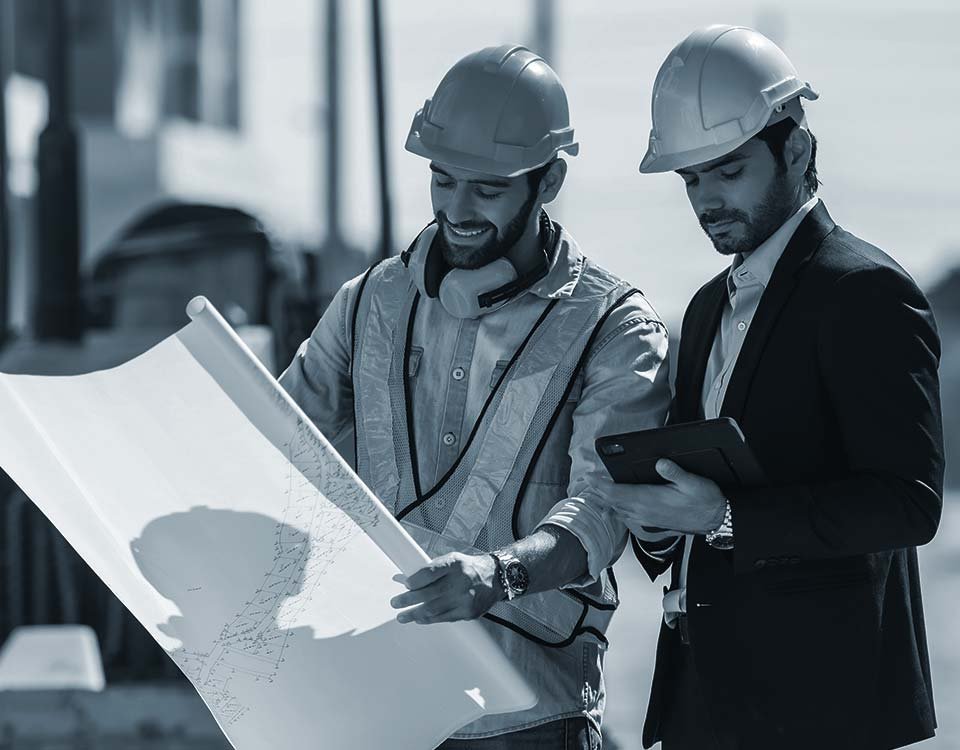 Equipo técnico de ingenieros y arquitectos de Constructora Marmo revisando planos de obra