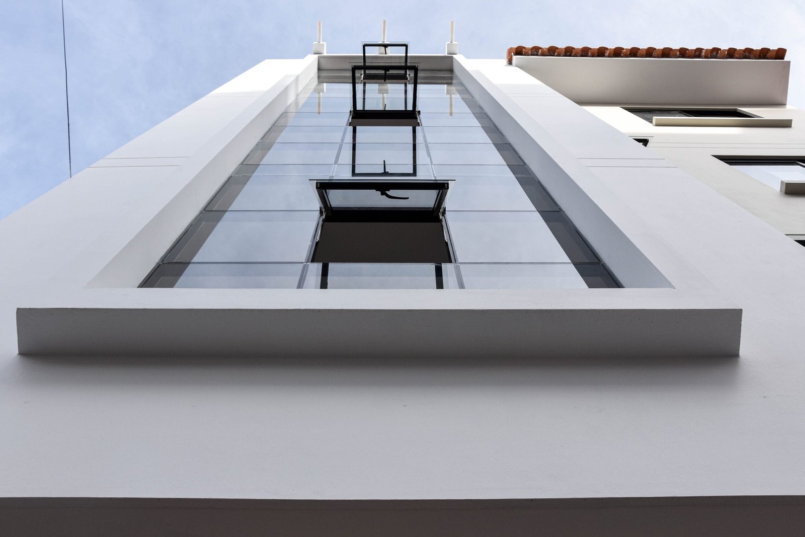 Fachada blanca del edificio multifamiliar David Durán con ventanal vertical continuo, vista desde abajo