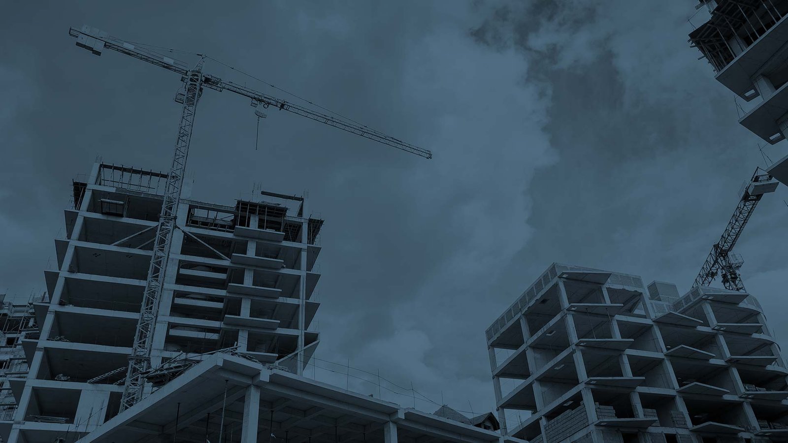 Edificios en construcción con grúa torre y estructura de hormigón armado