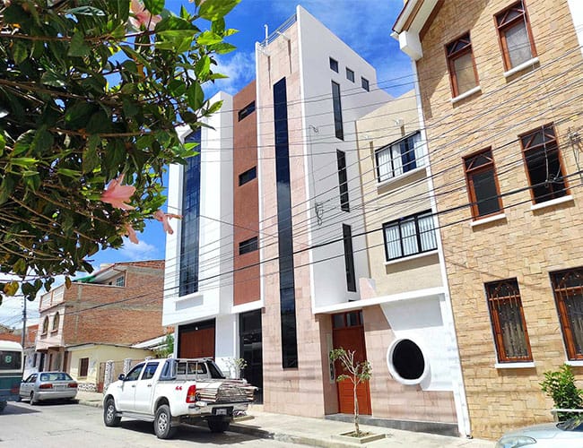 Residencia urbana I. Rivera con zócalo de piedra y ventanal vertical